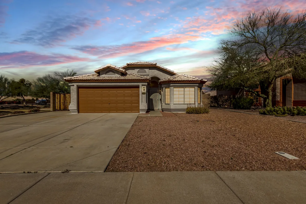 A serene view of the front entrance, garage door, and window details, framed by inviting landscaping. The scene suggests a comfortable return after a day exploring Peoria's ballparks and entertainment options.